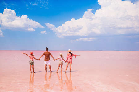 Family walk on a pink salt lake on a sunny summer day.の写真素材