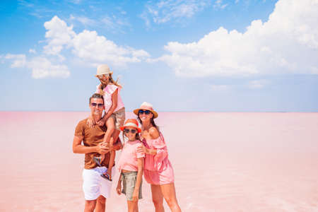 Family walk on a pink salt lake on a sunny summer day.の写真素材
