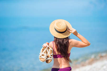 Young beautiful woman having fun on tropical seashore. Happy girl background the blue sky and turquoise water in the seaの写真素材
