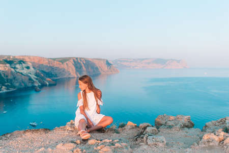 Happy kid outdoor on edge of cliff seashoreの写真素材