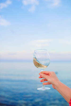 Glass of white wine on tropical beachの写真素材