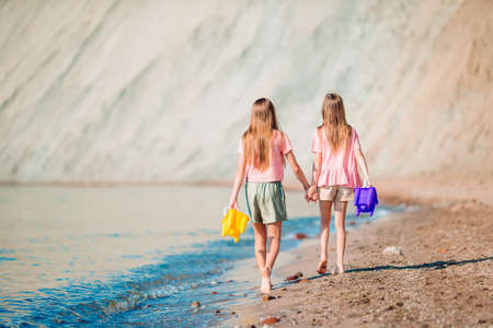 Adorable little girls having fun on the beachの写真素材