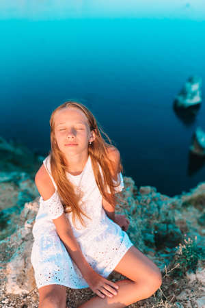Beautiful girl outdoor on edge of cliff seashoreの写真素材
