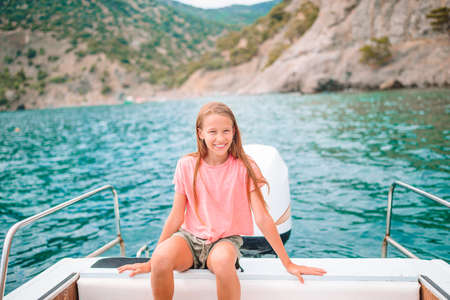 Little girl sailing on boat in clear open seaの写真素材
