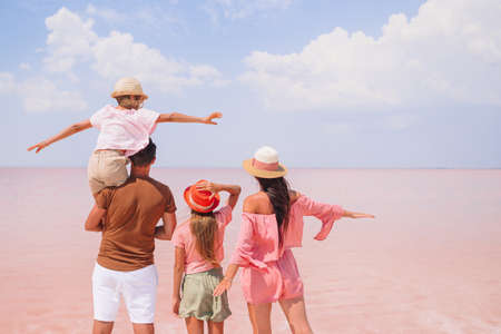 Family walk on a pink salt lake on a sunny summer day.の写真素材