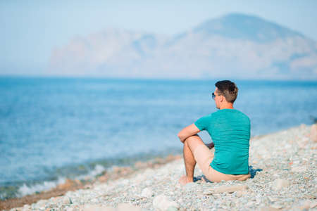 Young man on the white beach on vacation