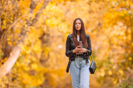 Fall concept - beautiful woman in autumn park under fall foliageの写真素材