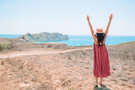 Tourist woman outdoor on edge of cliff seashoreの写真素材