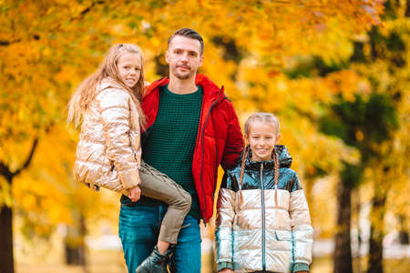 Family of dad and kids on beautiful autumn day in the park