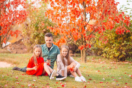 Family of dad and kids on beautiful autumn day in the parkの写真素材