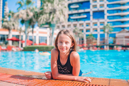 Little adorable girl in outdoor swimming pool