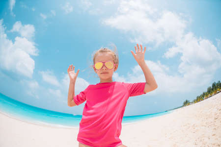 Adorable little girl have fun at tropical beach during vacation