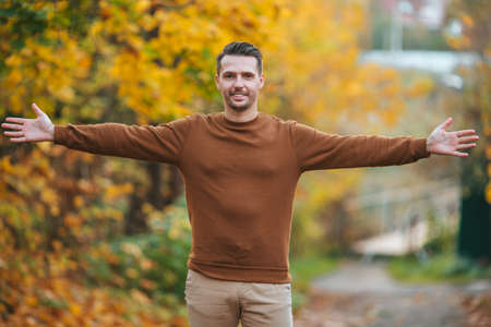 Young man in autumn park outdoorsの写真素材