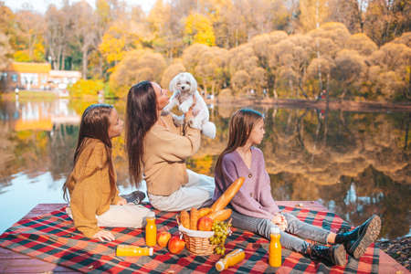 Happy family on a picnic in the park at autumnの写真素材