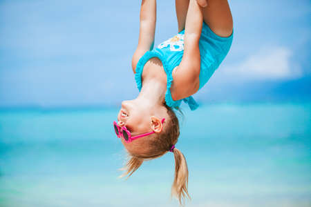 Little girl and happy dad having fun during beach vacation