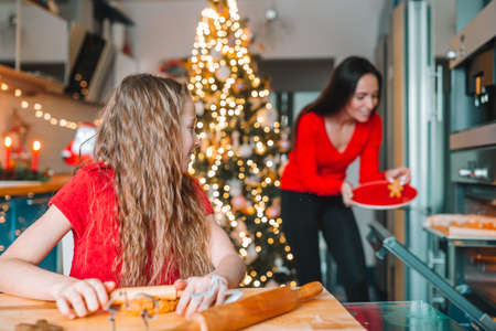 Happy family mother and daughter bake cookies for Christmasの写真素材