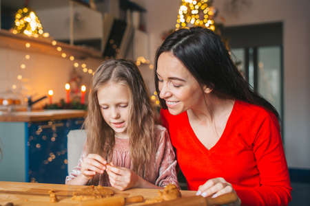 Happy family mother and daughter bake cookies for Christmasの写真素材