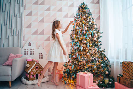 Beautiful girl near Christmas tree decoratingの写真素材