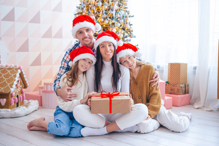 Happy young family with kids holding christmas presentsの写真素材