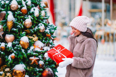 Happy girl near fir-tree branch in snow for new year.の写真素材