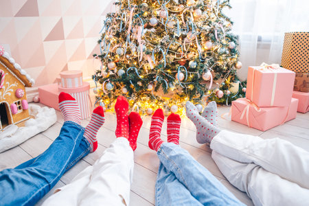 Close up photo of family feet in woolen socks by the christmas treeの写真素材