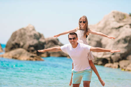 Little girl and happy dad having fun during beach vacationの写真素材