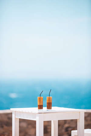 Coffee latte on wooden table with sea background
