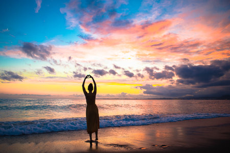 Young woman on the beach at sunset