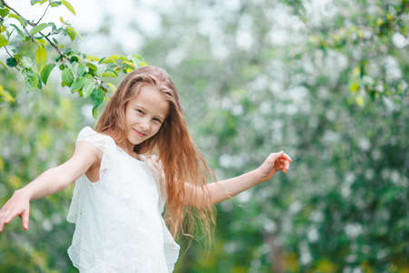 Adorable little girl in blooming apple garden on beautiful spring dayの写真素材