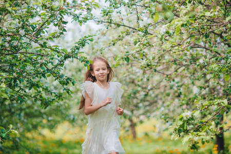 Adorable little girl in blooming apple garden on beautiful spring dayの写真素材