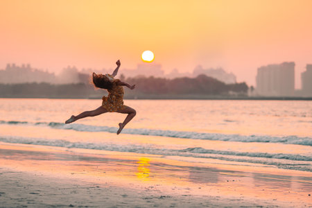 Adorable happy little girl on white beach at sunset.の写真素材