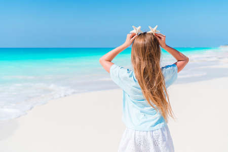Adorable little girl have fun at tropical beach during vacationの写真素材