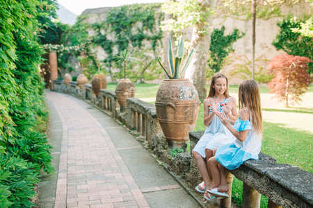 Adorable little girls on warm and sunny summer day in Positano town in Italyの写真素材