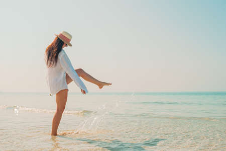 Woman laying on the beach enjoying summer holidays looking at the seaの写真素材