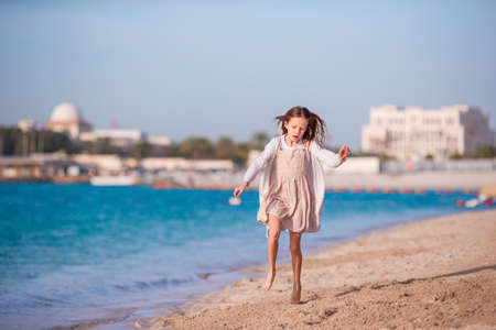 Adorable little girl have fun at tropical beach during vacationの写真素材