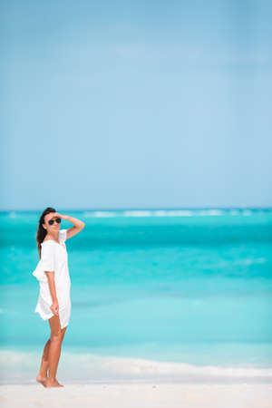 Young beautiful woman having fun on tropical seashore. Happy girl background the blue sky and turquoise water in the sea on caribbean islandの写真素材