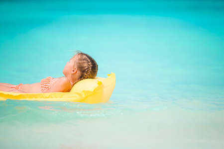 Portrait of little girl with inflatable rubber circle on beach vacationの写真素材