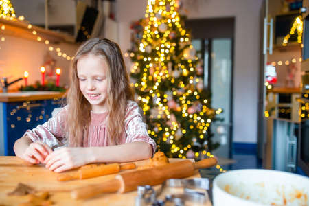 Adorable little girl baking Christmas gingerbread cookies