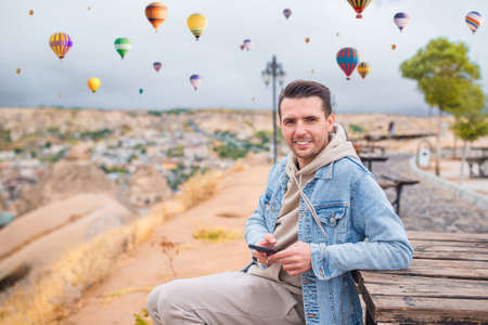 Happy young man watching hot air balloons in Cappadocia, Turkeyの写真素材