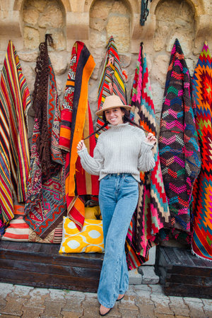 Old traditional Turkish carpet shop in cave house Cappadocia, Turkey Kapadokya. Young woman on vacation in Turkeyの写真素材