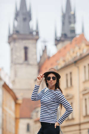 Happy young woman in hat on the street of european city.の写真素材