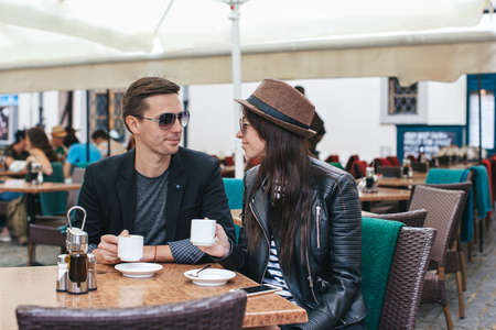 Romantic loving couple drinking coffee, having a date in the outdoor cafe
