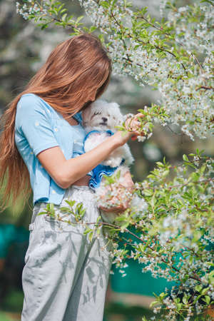 Adorable little girl in blooming apple garden on beautiful spring dayの写真素材