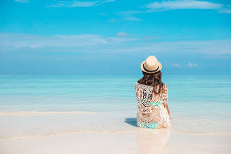 Woman laying on the beach enjoying summer holidays looking at the sea