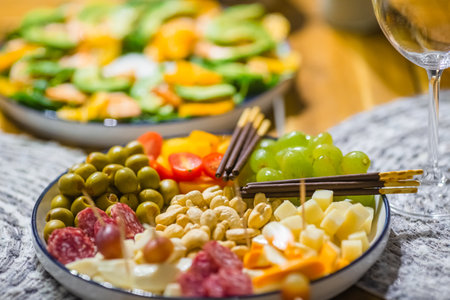 Appetizers plate with different snacks, cheese, olives, fruits and nutsの写真素材