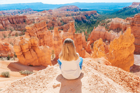 Little girl in Bryce Canyon hiking relaxing looking at amazing view during hike on summer travel in Bryce Canyon National Park, Utah, United States.の写真素材