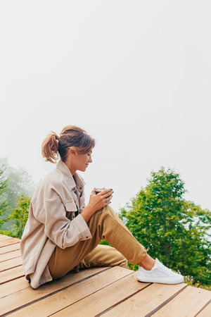Beautiful happy woman in mountains in the background of fog