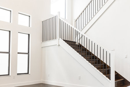 Modern white wooden staircase in new house interior with big windowsの写真素材