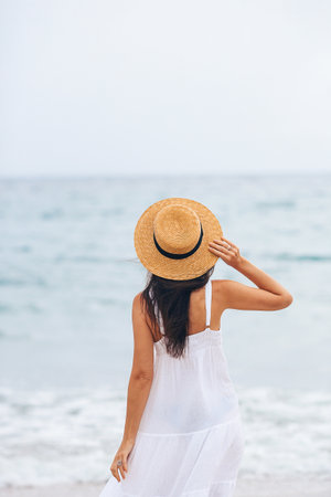 Happy woman enjoying beautiful sunset on the beachの写真素材