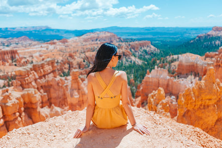 Hiker woman in Bryce Canyon resting enjoying view in beautiful nature landscape with hoodoos, pinnacles and spires rock formations in Utahの写真素材
